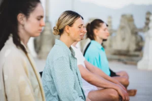 Donne in fila che respirano rilassate durante una meditazione